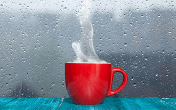 красная чашка с горячим напитком и дождливое осеннее утро за окном