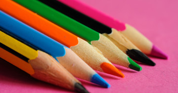 цветные карандаши на розовом листе