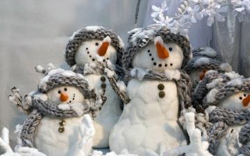 веселые снеговики в шапках и шарфах