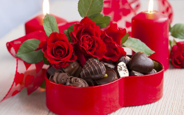 Алые розы в коробке с шоколадными конфетами зажжённые свечи романтика праздник